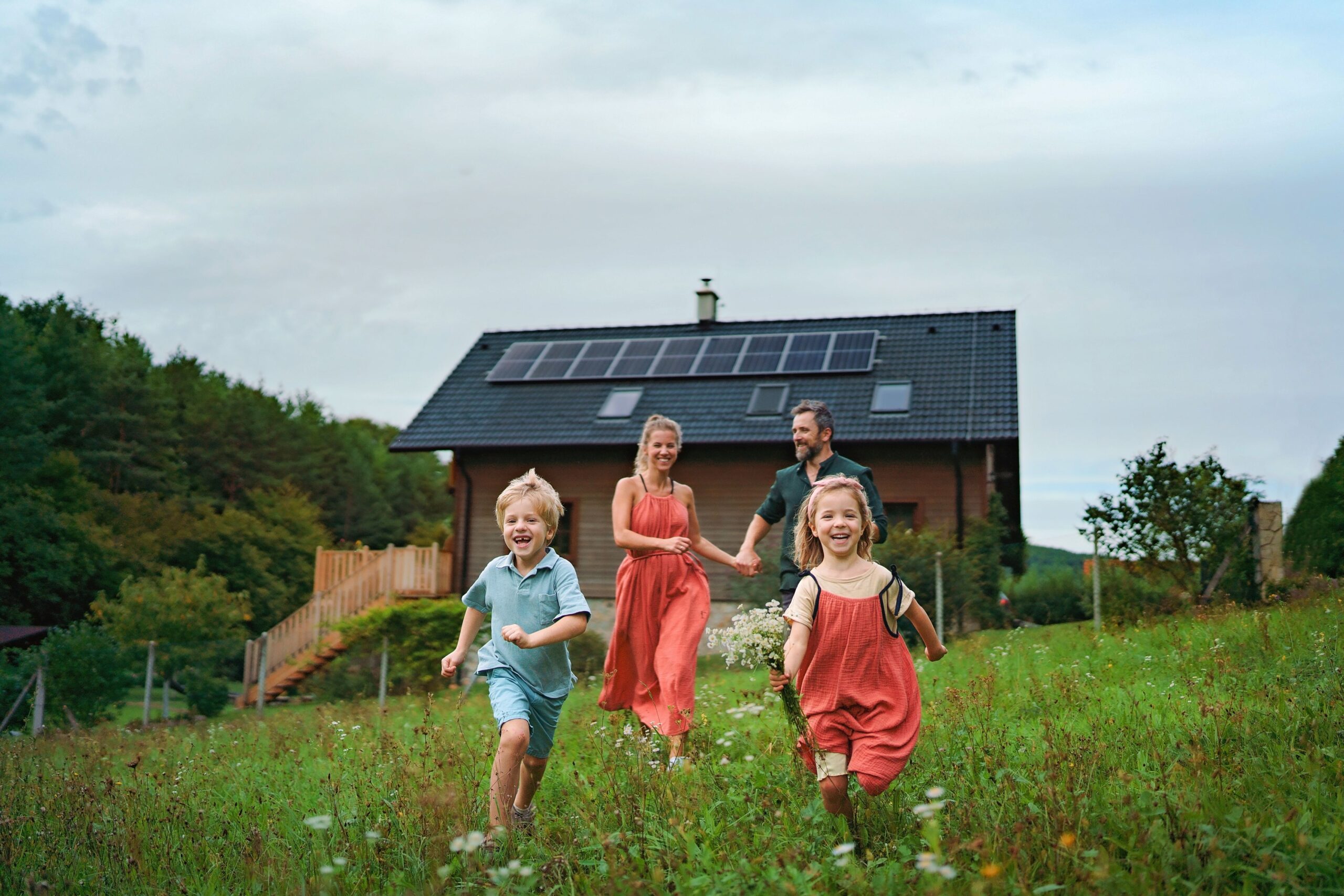 Familie vor Haus mit Photovoltaikanlage auf dem Dach in Duisburg