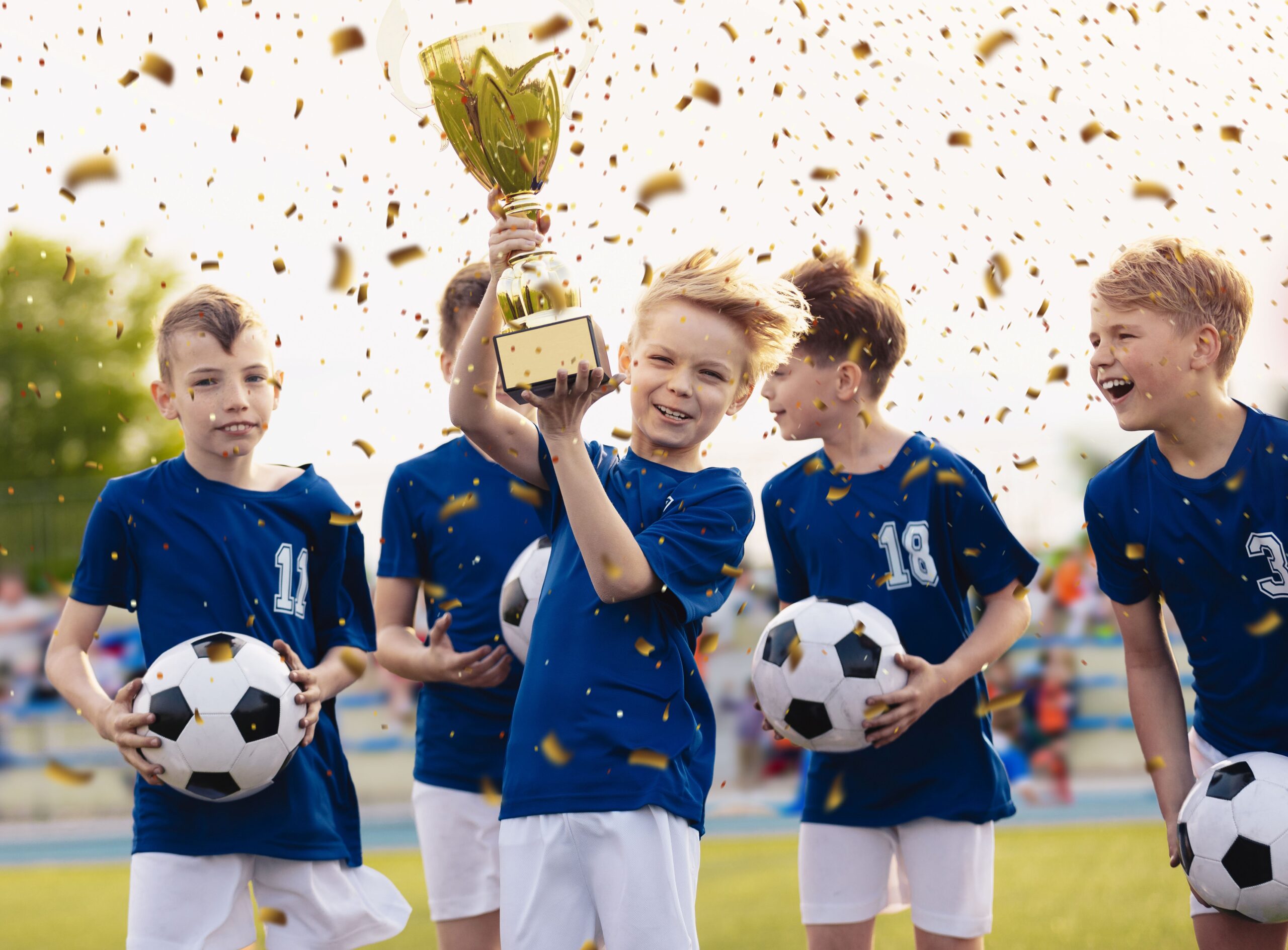 Junge Fußballmannschaft feiert Turniersieg mit Pokal