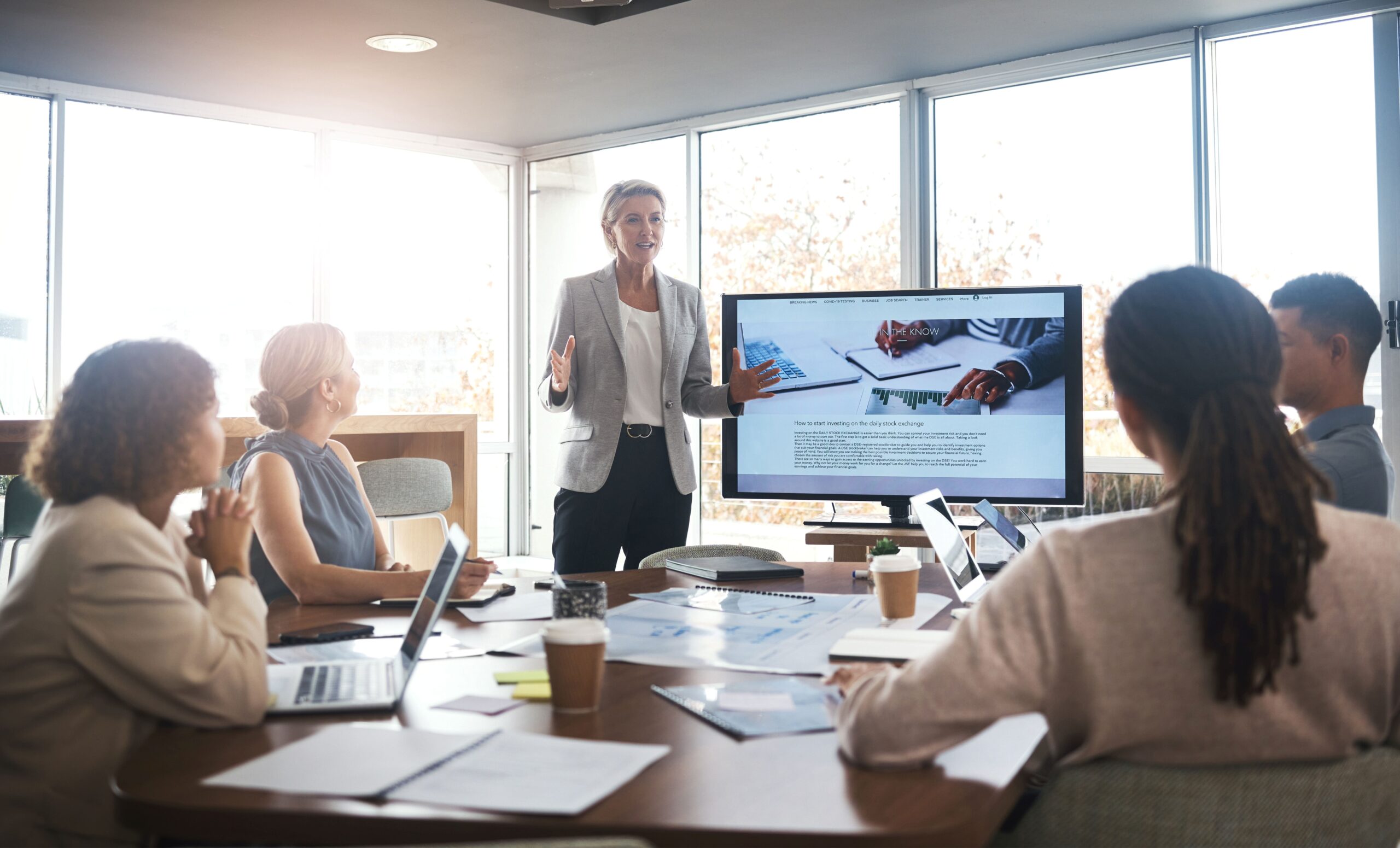 Business-Team diskutiert Daten vor Bildschirm – Meeting zur Optimierung von Online Seminarverwaltung mit Kennzahlen