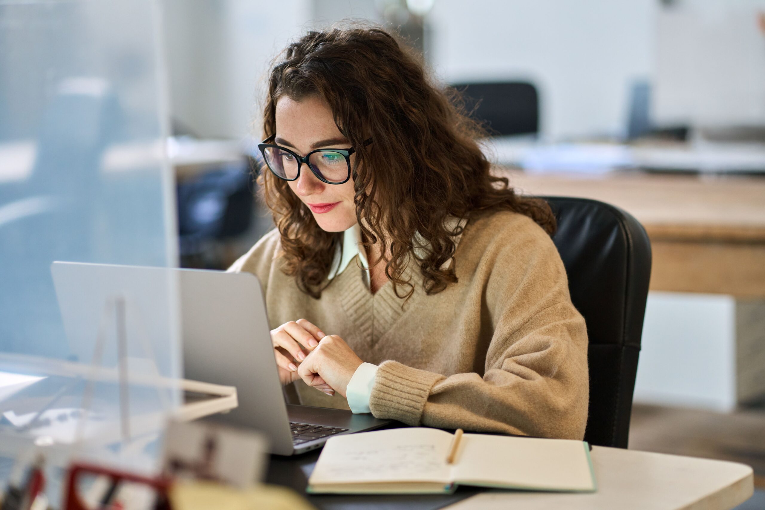 Frau arbeitet fokussiert am Laptop im Büro – Symbolbild für effiziente Online Seminarverwaltung und digitale Planung
